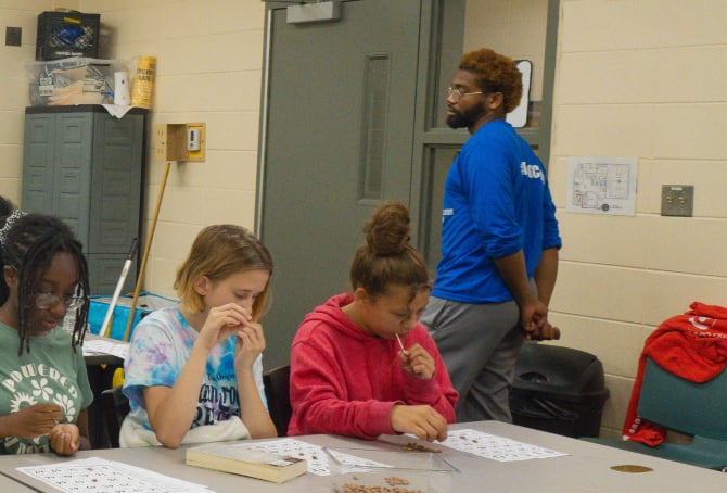 Volunteer monitoring children in classroom